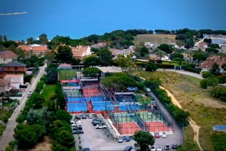 Aerial view of Can Teixidó Pàdel Club with full padel courts layout and the Mediterranean Sea in the background