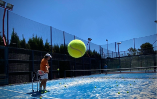 Padel trainer coaching a player in a one-on-one session at Can Teixidó Pàdel Club