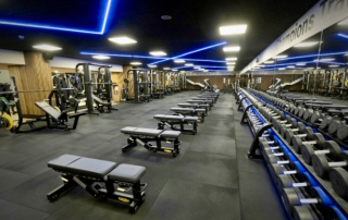Another angle of a luxurious, members-only fitness room at Club Natació Atlètic-Barceloneta featuring high-end training equipment and a quiet workout environment.