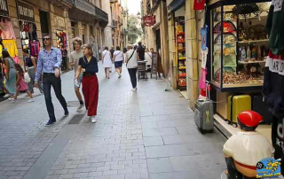 Daylight street view of downtown Mataró with people relaxing at cafés after playing padel at Bee-Padel