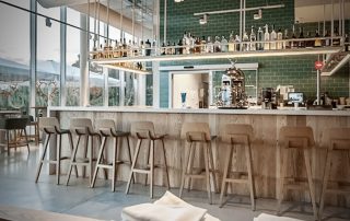Bar and indoor dining area of Restaurant Sorli Emocions below the rooftop infinity pool at Hotel Sorli Emocions, just 50 meters from Bee-Padel Academy