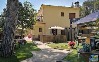 View from the entrance of Villa Cal Music B&B showing the lush garden and two room terraces on the right