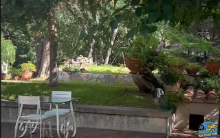 Charming garden terrace at Masia Can Casadellà set for breakfast, surrounded by tropical plants and fragrant flowers