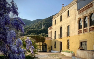 Impressive front view of Masia Can Casadellà with its grand entrance, colonial architecture, and elegant Mediterranean style