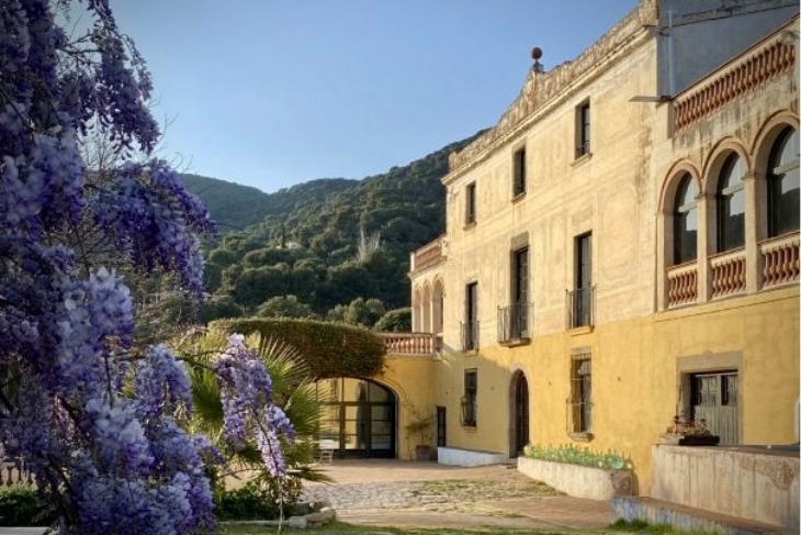 Impressive front view of Masia Can Casadellà with its grand entrance, colonial architecture, and elegant Mediterranean style
