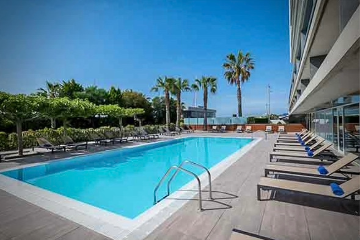 Outdoor swimming pool and sunny terrace of Hotel Atenea Port Mataró near the beach