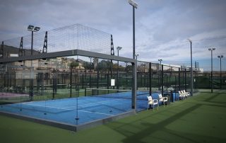 Panoramic view of the centre padel court at Masnou Ocata Padel Club with ample outdoor space for players to run and retrieve balls