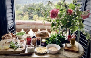Close-up of a beautifully set breakfast table at Masia Can Casadellà with fresh organic food and healthy artisanal bread
