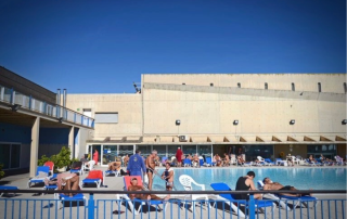 Padel players and guests relaxing on a sunlit terrace at Club Natació Atlètic-Barceloneta after intensive training.
