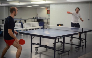 Action shot of table tennis players competing in the professional ping pong training area at CNAB in Barcelona.