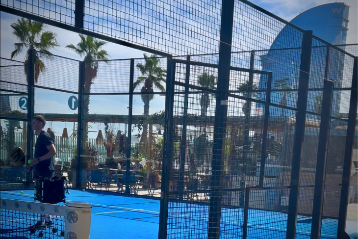 Spain’s top padel trainer Roger Pascual with Bee-Padel players on court at CNAB Barceloneta, with the W Hotel and beach in the background