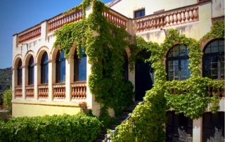 Side view of Masia Can Casadellà on the border of Barcelona, featuring a stunning outdoor staircase wrapped in lush climbing plants