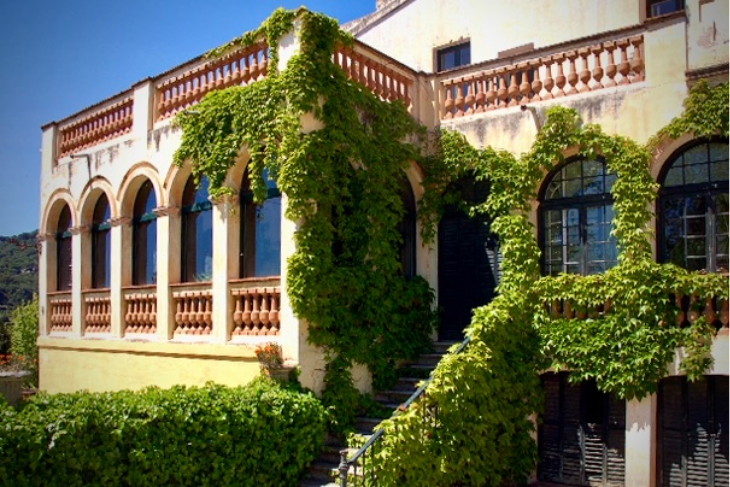 Side view of Masia Can Casadellà on the border of Barcelona, featuring a stunning outdoor staircase wrapped in lush climbing plants