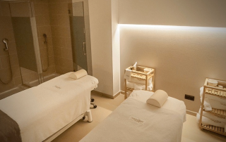 Luxury wellness treatment room at SorliSport featuring two massage beds and elegant showers, offering complete care and relaxation.
