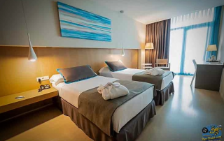 Room at Hotel Atenea Port Mataró with two queen-size beds and balcony view