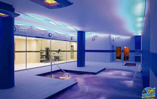 Indoor swimming pool with adjacent fitness area at URH Ciutat de Mataró for guest relaxation and training