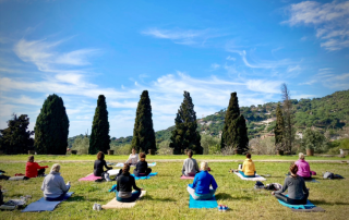 Group of people meditating during a relaxing yoga class at Masia Can Casadellà surrounded by nature